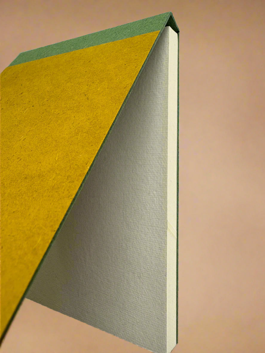 Book with a yellow and green cover on a white background biodegradable notepad eco friendly notebook
