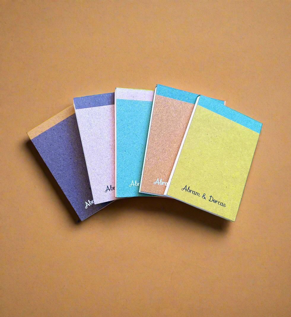 Set of small notebooks with different colored covers on a textured surface biodegradable notepad