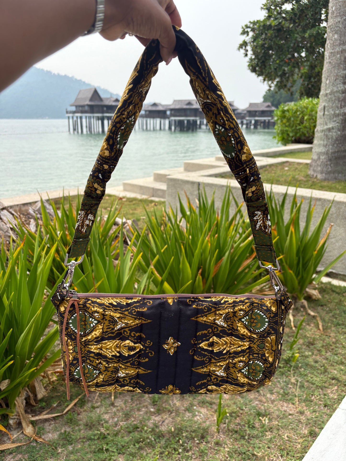 Handcrafted quilted black batik bag with leather zipper puller and YKK zipper, features a detachable padded shoulder strap.