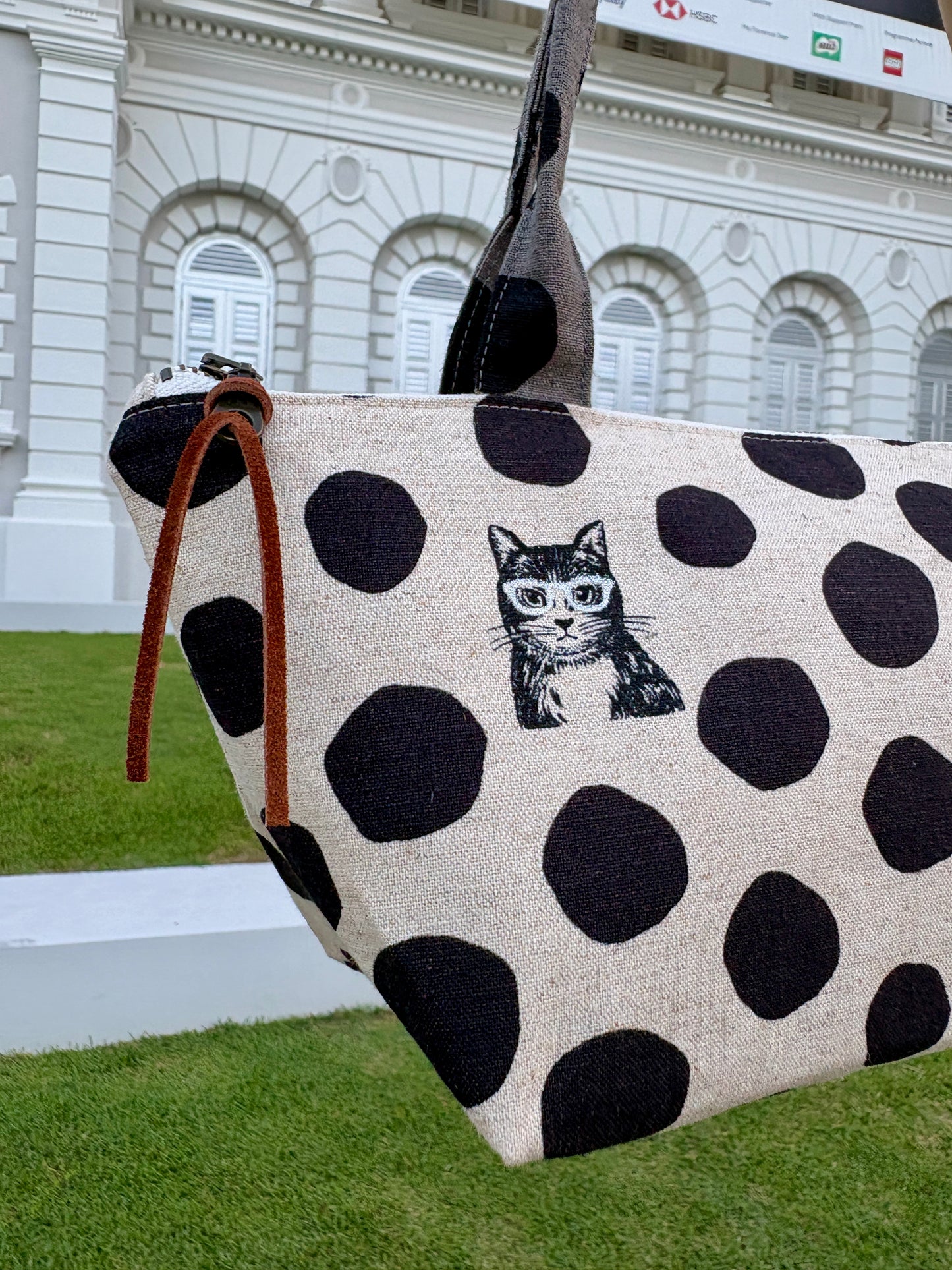 Polka dot handbag made from Japanese canvas featuring a cat print, handmade in Singapore. Finished with a YKK zipper and leather zipper puller.