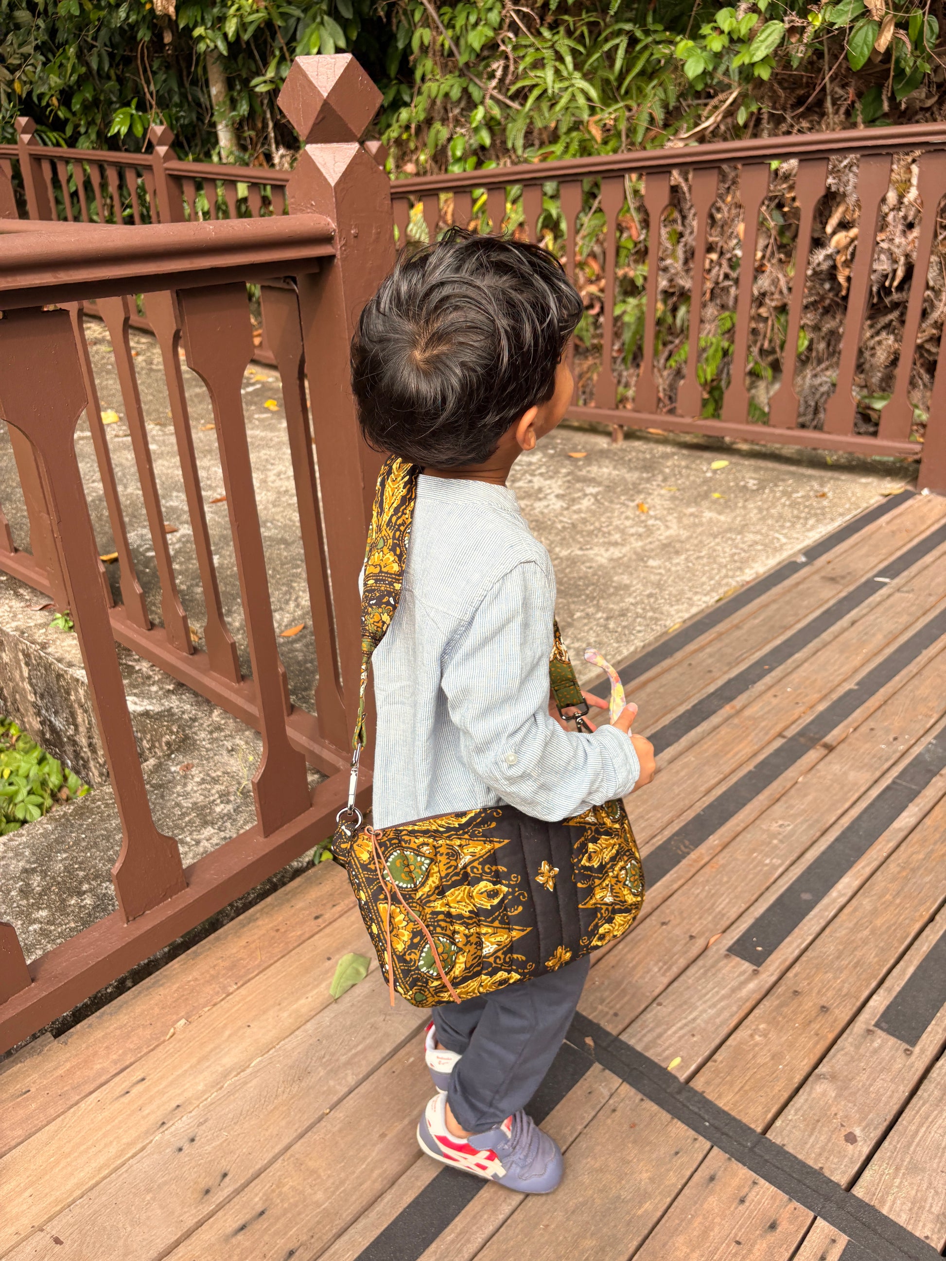 Handcrafted quilted black batik bag with leather zipper puller and YKK zipper, features a detachable padded shoulder strap.