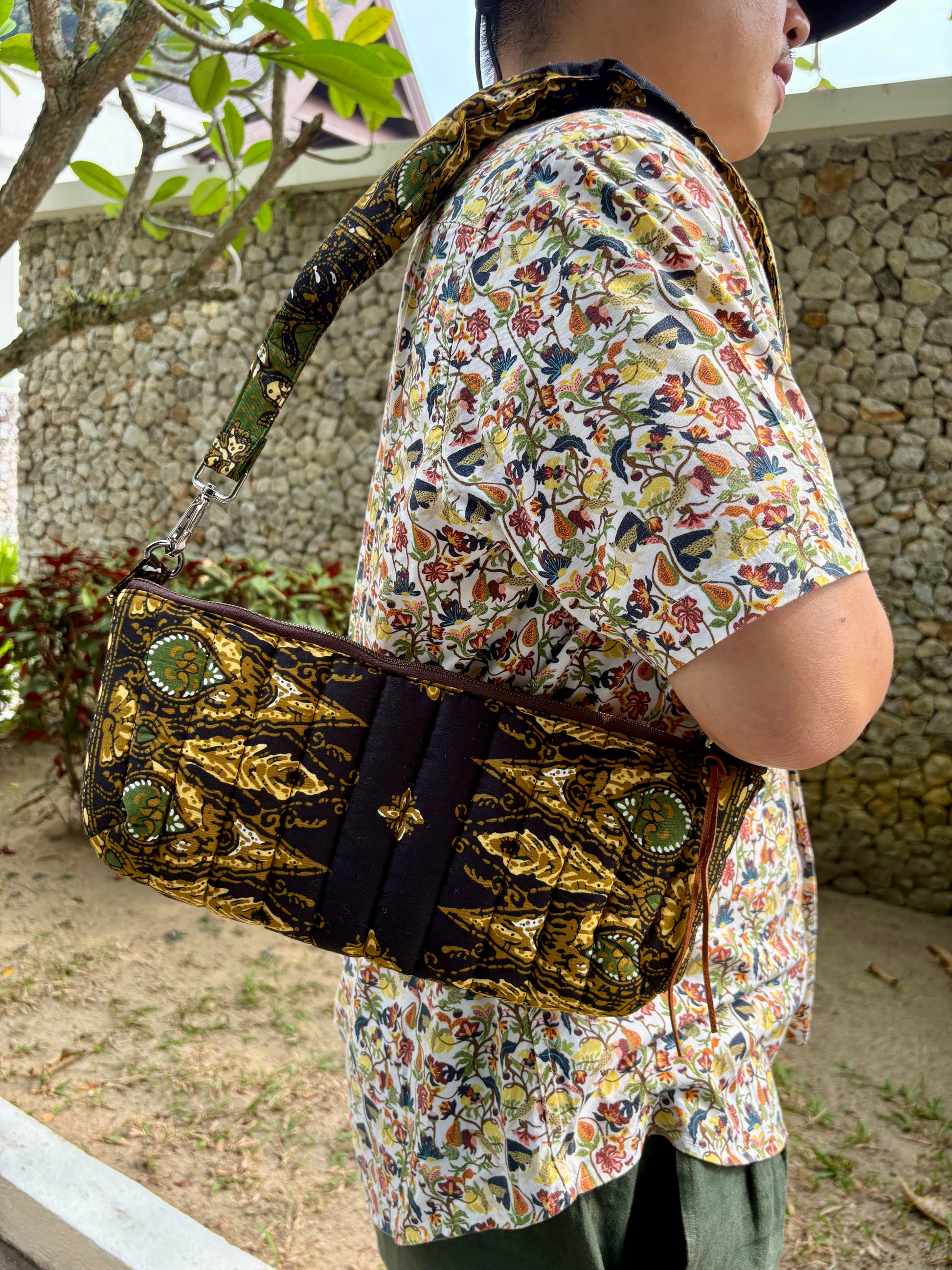 Handcrafted quilted black batik bag with leather zipper puller and YKK zipper, features a detachable padded shoulder strap.