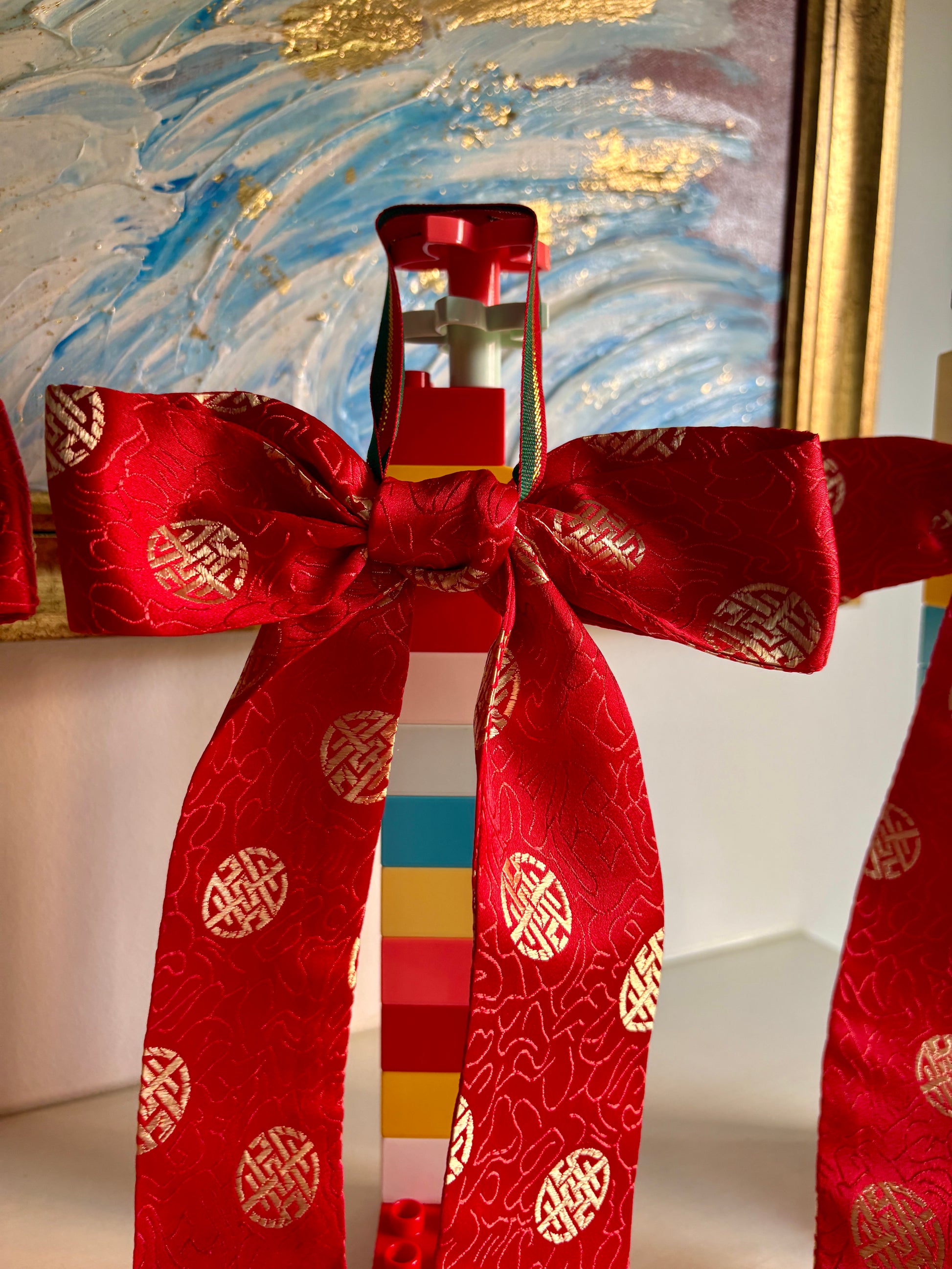 Red bows handmade in Singapore from red brocade fabric featuring Chinese characters.