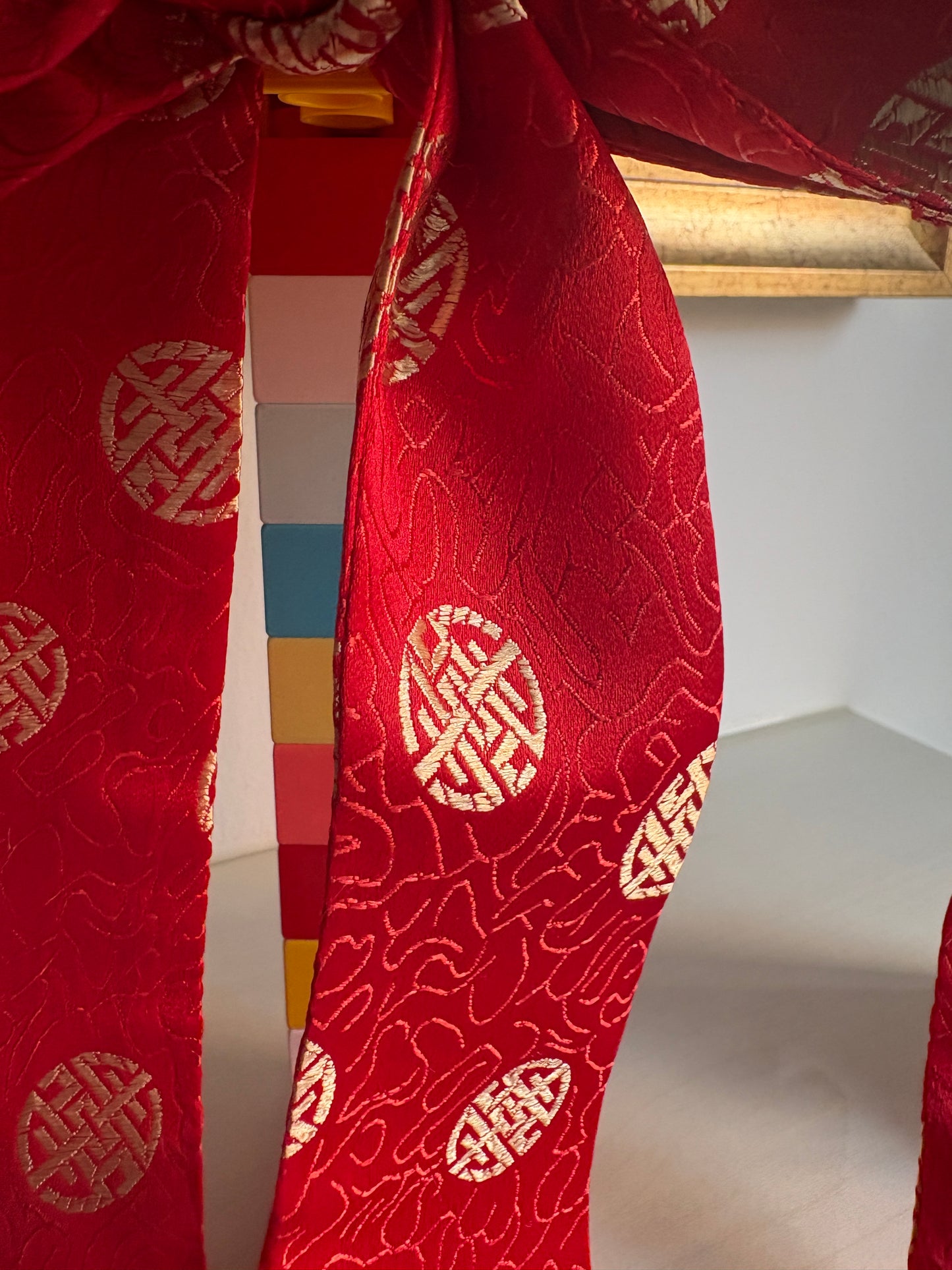 Red bows handmade in Singapore from red brocade fabric featuring Chinese characters.