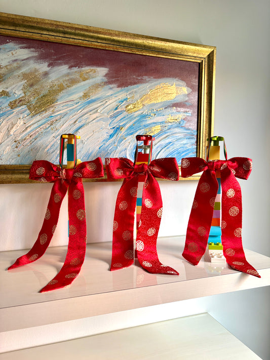 Red bows handmade in Singapore from red brocade fabric featuring Chinese characters.
